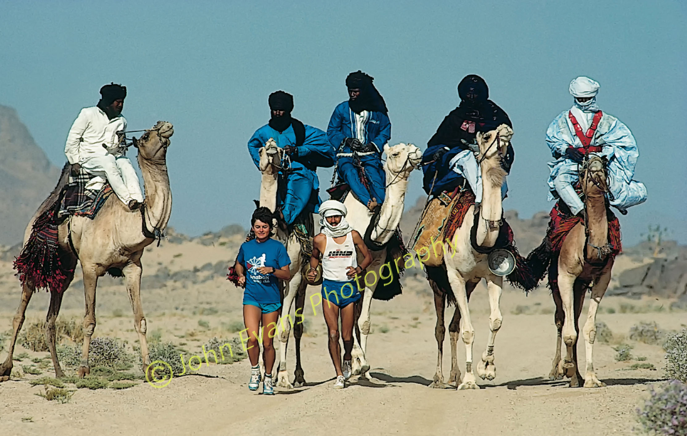 Locals on camels accompany the Hoggar Super Marathon runners during the 104-mile, 4-day race. Algerian Sahara, 1989